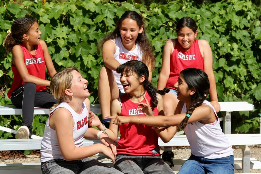 Girls in Girls Inc. shirts talking and laughing
